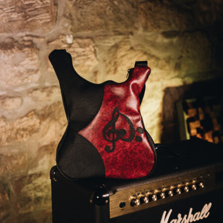 Burgundy leather guitar shaped bag decorated with music notes