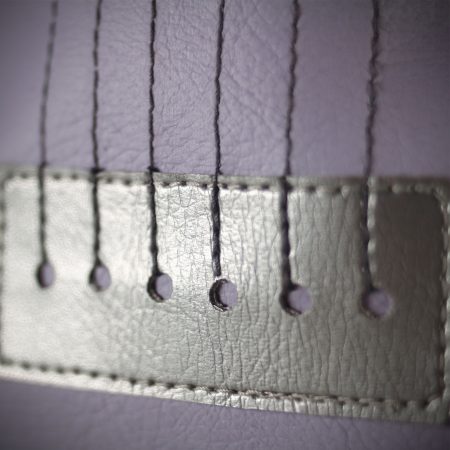Lavender backpack in guitar-shaped design with sewed strings and studded guitar knobs