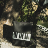 Black and white leather piano backpack, the perfect accessory for music lovers.