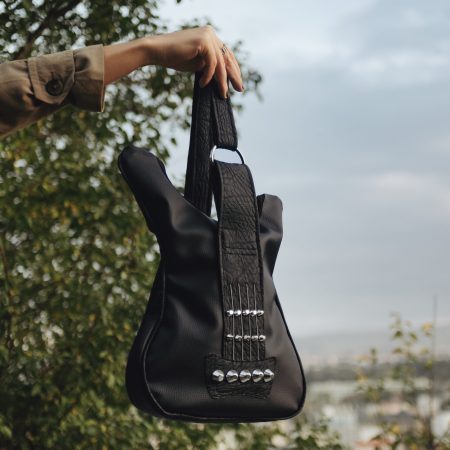 Black leather bass bag with real guitar strings, a perfect rock-themed accessory from Bysolbags